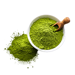 Bright green powder in a large white bowl with a wooden scoop inserted into the powder.